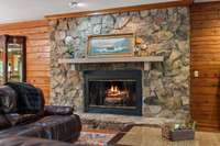 Gather around the gas starter fireplace, framed by elegant stone surroundings.