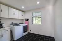 Large upstairs laundry room with elegant black tile flooring