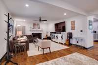 Living room with fireplace, hardwood flooring, & modern fixtures