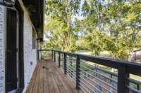 Rear balcony overlooks deck, firepit, and sprawling rear lawn