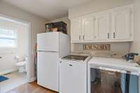 Laundry room just off kitchen features additional fridge and pantry. Full bath with shower is also adjoining.