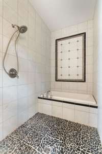 Large walk in shower with soaking tub, offers a spa like experience.