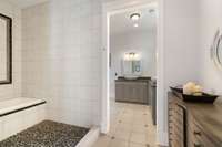 A spacious en suite bathroom with dual sinks and walk in shower.