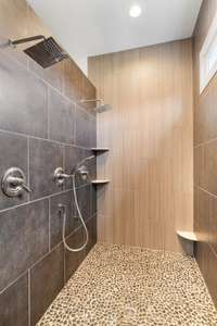 This large walk in shower has two rain shower heads and a wand offering a spa like experience.