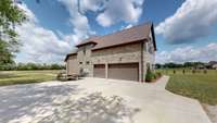 3 car garage, with ample concrete pad parking