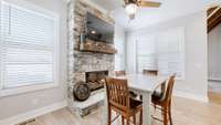 Gathering room/breakfast nook houses the 3rd Stacked Stone gas log fireplace, flanked by walls of windows overlooking the gorgeous pool and back acreage!