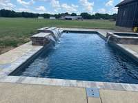 View 2 of this gorgeous pool, featuring 3 waterfalls and a custom decorative firewall.  You can sit on the screened-in porch, complete with fireplace, and enjoy the pool!