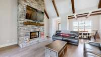 One of 3 stacked stone gas log fireplaces in the home.  Great Room also features the beautiful cedar beam cathedral ceiling accents