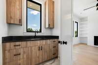 Custom Italian cabinets extend into the laundry room which has a sink and ample built-ins