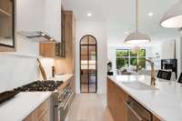 Beautiful, arched door was custom fabricated with black-frame detail to match the glass-front cabinets, leading to the butler's pantry