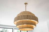 Stunning lighting throughout this home includes this textured & tiered fixture in the living room