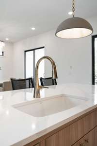 White porcelain sink pairs beautifully with the quartz counters and upgraded French gold faucet