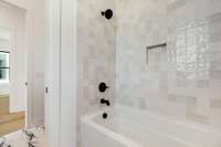 Secondary bath with textured tile that extends all the way to the ceiling