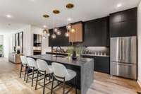 Elegance and drama abound in this gorgeous matte black kitchen with high-end Dekton countertops  and dreamy island pendants