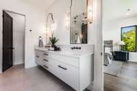 Fabulous floating vanity is light & sophisticated. Note the oversized backsplash and wall-mounted black faucets. Truly a spa-worthy primary bath!