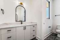 Gorgeous light & airy cabinetry in the secondary bath pops beautifully against the darker floors and hardware