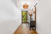 Stained wood glass door brings in beautiful light to the entryway