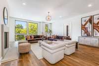 Another view of the open concept living room with beautiful light from the floor-to-ceiling black windows