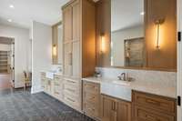 The double vanities feature custom white oak cabinets and marble countertops.