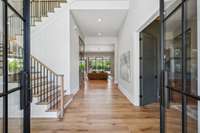 The double front doors invite you into the grand entryway with soaring ceilings and a beautiful white oak stairwell.