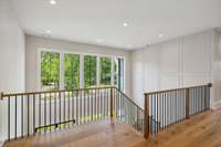 The upstairs foyer is filled with natural light and surrounded by the beautiful handrail.