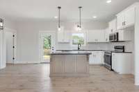 Stunning open concept kitchen, dining, and living room with custom built cabinetry and granite countertops!