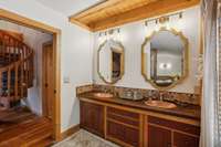 Primary bath features updated lighting, renovated shower, glamorous gold accents, and a soaking tub