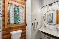 Secondary suite has a floor-to-ceiling renovated en suite bath with double farm sink and sleek shower