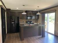 Kitchen with plenty of cabinets/counter space! Pantry to the left with sliding barn type door. Appliances remain. Sliding door leads to the back deck.