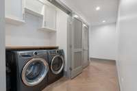 Full-size Electrolux W/D convey with property, and laundry area also features built-in storage and countertop.