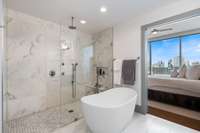 Primary bath with marble tile, huge shower, and separate soaking tub.