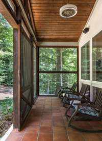 Enjoy the outdoors from the comfort of this screened patio, where you can relax without worrying about the elements. Imagine yourself enjoying quiet mornings or evening dinners in this peaceful space.