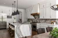 Designed for both beauty and function, this gourmet kitchen boasts custom fixtures and gleaming quartz countertops. Picture yourself preparing meals in this inviting space, with everything you need at your fingertips.