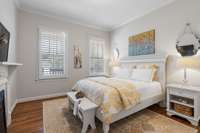 First floor en suite bedroom with plantation, crown molding and wood floors.