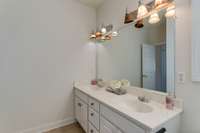 The guest bathroom features a double vanity, perfect for accommodating multiple guests. The sleek tile flooring adds a touch of elegance.