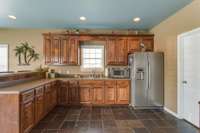 The full kitchen is equipped with custom cabinetry, lots of counterspace, a microwave and a refrigerator.