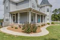 The sidewalk leads to the front door and side entry door of wrap around porch.