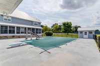 The large screened back porch overlooks the pool area. The pool has a pump house that also provides storage for pool accessories.