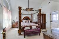 The spacious primary bedroom has plush carpeting and a vaulted ceiling that creates a sense of openness and airiness.