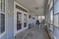 A screened-in back porch w/plenty of windows, offers a bright & airy space perfect for relaxation. The French doors lead to the kitchen & provide easy access for outdoor entertaining. The screen door leads to the pool area.