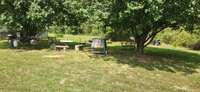 Picnic area with concrete table, fire pit and grill.