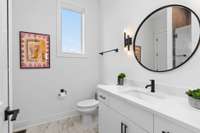 The window in the accompanying bathroom makes this space bright and sleek. The white marble vanity offers plenty of cabinet space below.