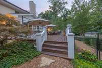 Deck overlooking private back yard with large trees.