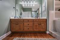 Double vanity in the primary bath downstairs with separate shower and tub.  Nice built-in storage for towels above tub.