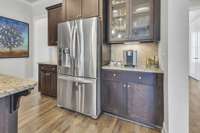 Under cabinet lighting. LG French door refrigerator.  Cabinets on either side of the fridge are ideal for a coffee bar and charging station setups.