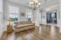 View from formal dining room/sitting room towards the entry and office.  Notice the views of common area from the living room windows.  Very open and bright. Ideal space for a music room or reading room.