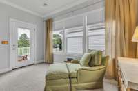 Primary bedroom has room for a sitting area.  French door to private back deck provides sunset views.