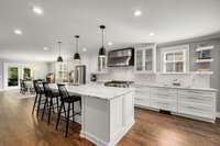 The kitchen features marble counters, tile backsplash, and a huge island with seating.