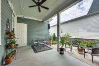 Back covered patio which could be screened or left open. Ceiling fan and one step down to the patio and garden area. Door leads to the 2 car garage.