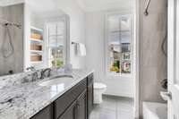 Hall bathroom with new paint, tile floors, and excellent natural light.